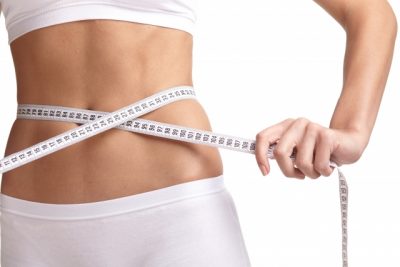 ダイエットでウエストを測っている女性
