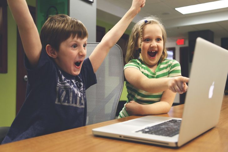 パソコンの画面を見て喜ぶ子供たち